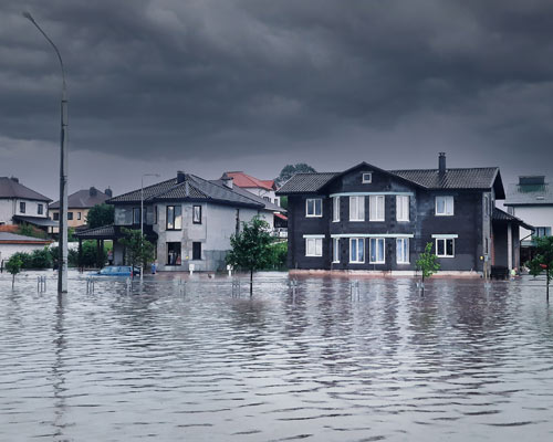 flooded street with homes in background